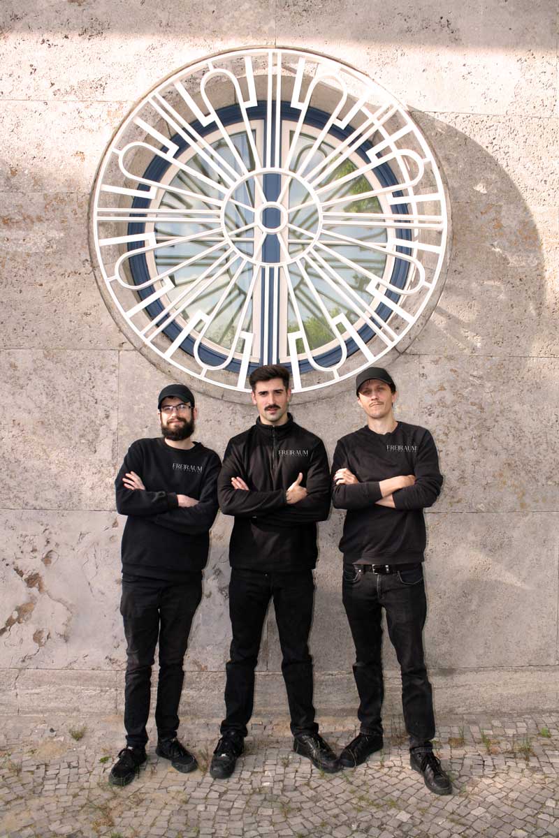 Das Team von Freiraum-Auflösungen – drei Mitarbeiter in schwarzer Arbeitskleidung mit Firmenlogo